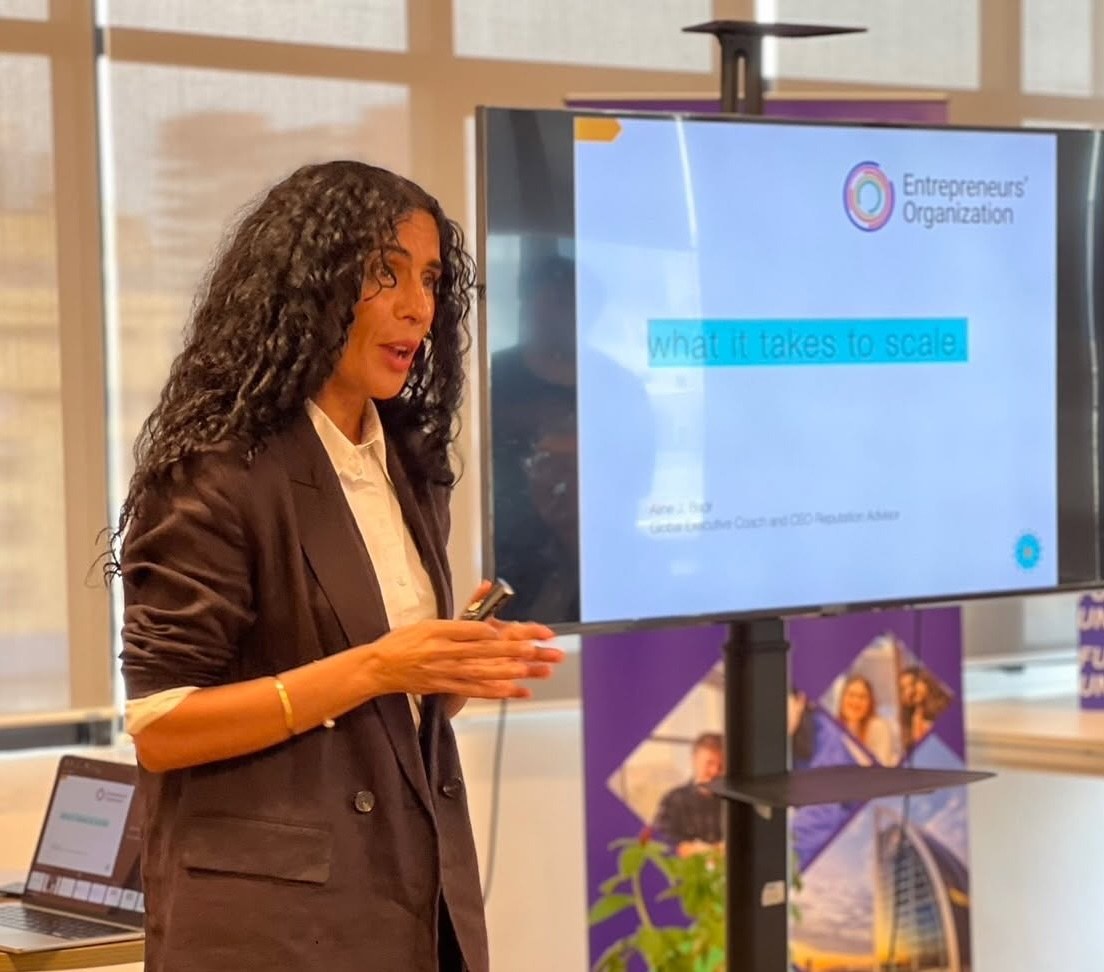 Aline presenting beside an Entrepreneurs’ Organization screen