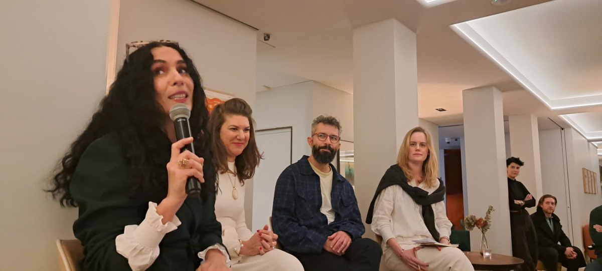 Aline speaking into a microphone during a panel discussion