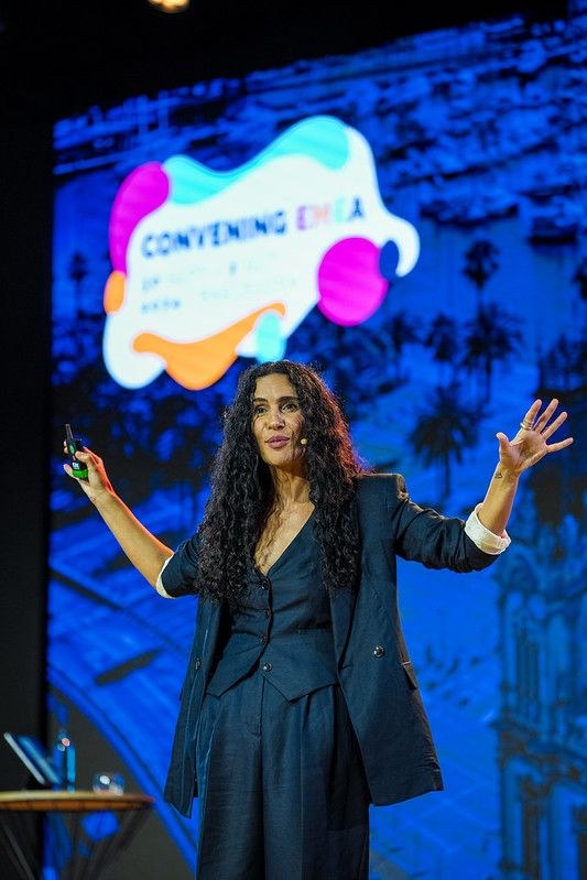Aline speaking with outstretched hands at PCMA Convening EMEA